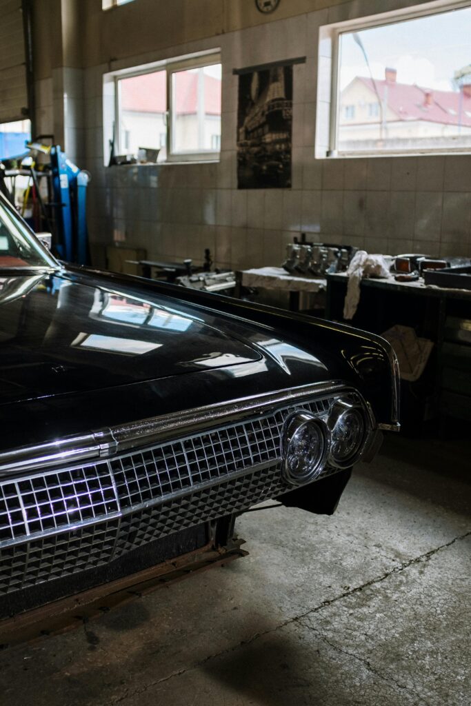 Close-up of a classic car in a garage, showcasing vintage design details.